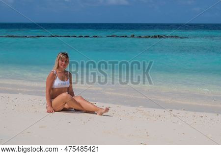 Woman In White Bikini Under Palm, Ocean And Sand Beach On Backgroud. Crossroads Maldives, Saii Lagoo