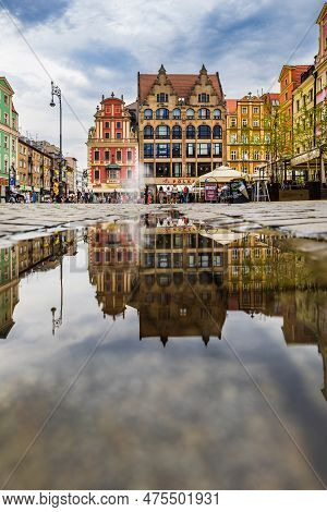 Wroclaw, Poland - July 2022: Wroclaw Market Square Old Tenement Houses Reflected In Small Puddle