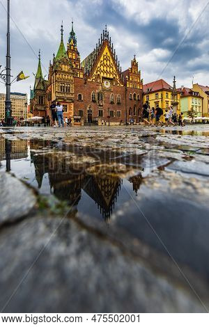 Wroclaw, Poland - July 2022: Wroclaw Market Square Old Tenement Houses Reflected In Small Puddle