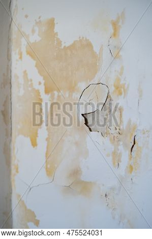 Damaged Wall With Chipped Paint And Plaster In Traces Of Leak From Faulty Water Supply At Neighbours