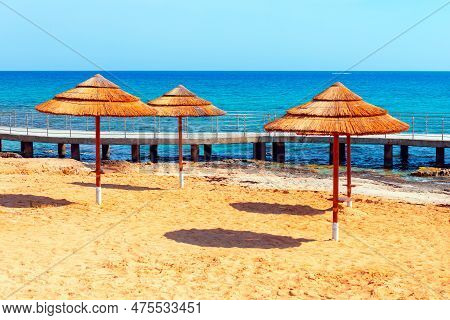 Straw Sun Umbrellas At Tropical Beach . Musan Beach In Cyprus