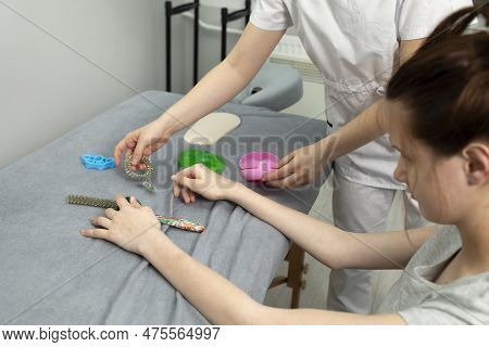 Female, Teenager With Disability Stretches Fingers With Physical Therapy Equipment. Health Specialis