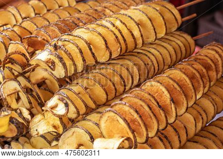 The Fried Potatoes Cut In The Form Of A Spiral On Skewers. Chips Potatoes. Organic Food. Street Food