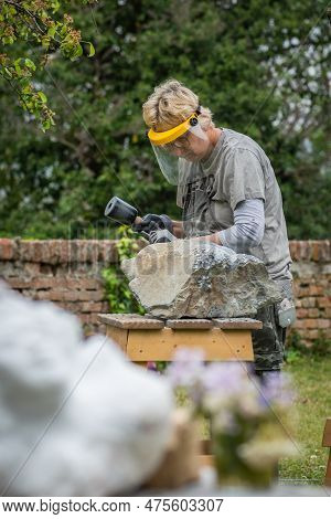 Sebastiano Da Po, Italy - April 12 2023: Woman Carving A Stone During An Outdoor Sculpture Lesson Or