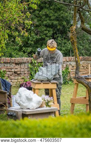 Sebastiano Da Po, Italy - April 12 2023: Woman Carving A Stone During An Outdoor Sculpture Lesson Or