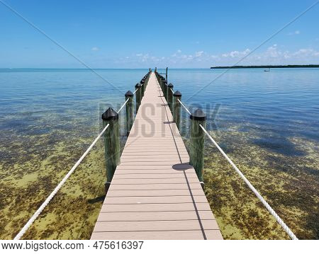 Tavernier, Florida - April 2, 2023 - Long Dock Extends Into Clear Calm Water In Tavernier Key On Sun