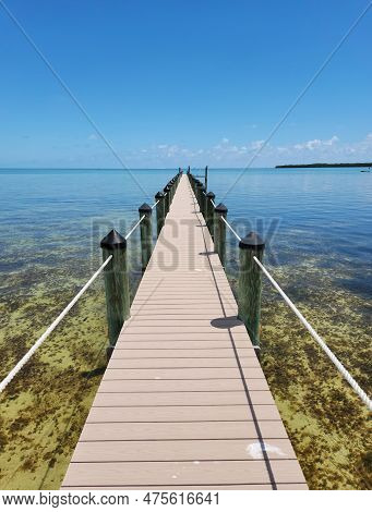 Tavernier, Florida - April 2, 2023 - Long Dock Extends Into Clear Calm Water In Tavernier Key On Sun