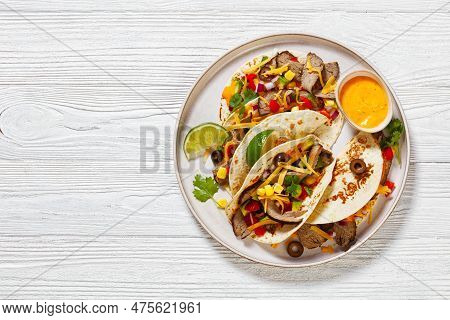 Grilled Steak Tacos With Olives, Tomatoes, Red Onion, Avocado, Cilantro, Corn, Shredded Cheddar Chee