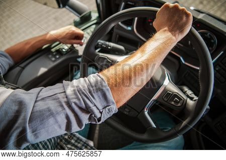 Truckers Hand On A Semi Truck Steering Wheel Close Up Photo. Caucasian Professional Driver Theme. Tr