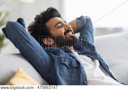 Home Comfort. Portrait Of Relaxed Young Indian Man Leaning Back On Couch