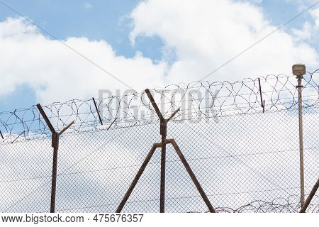 A Close-up Of A Barbed Wire Fence. Protected Area, Fenced Off With A High Metal Fence And Barbed Wir