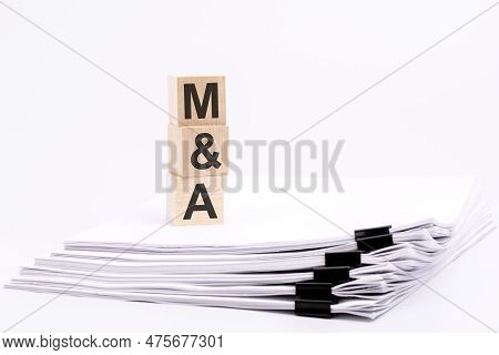 Wooden Blocks With Text M And A On White Table, Stack White Paper On Background