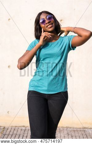 Sunkissed Summer Vibes: Portrait Of A Black Tourist Woman In Green Tee And Sunglasses