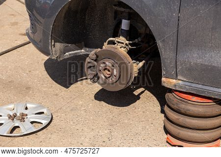 Car On Tire Mounting With Removed Wheel On Pneumatic Jack, Seasonal Tire Change, Car Service Concept