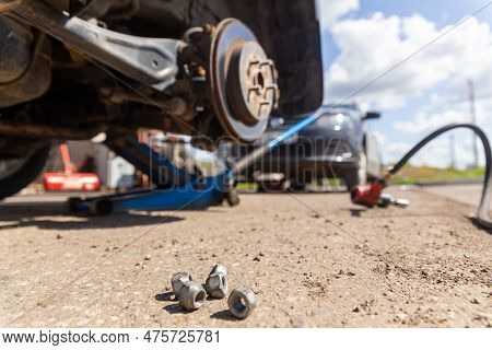 Car On Tire Mounting With Removed Wheel On Pneumatic Jack, Seasonal Tire Change, Car Service Concept