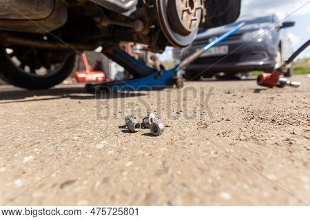 Car On Tire Mounting With Removed Wheel On Pneumatic Jack, Seasonal Tire Change, Car Service Concept