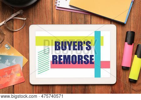 Tablet With Text Buyer's Remorse, Credit Cards And Stationery On Wooden Table, Flat Lay