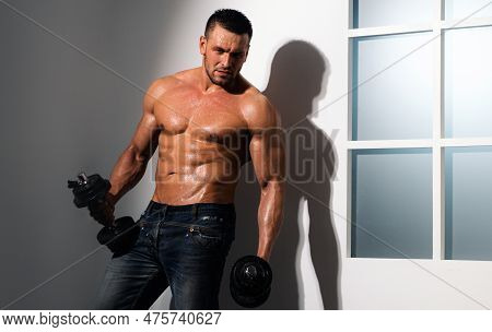 Athletic Male Sports Man Pumping Up Arm And Biceps Muscles With Dumbbell.