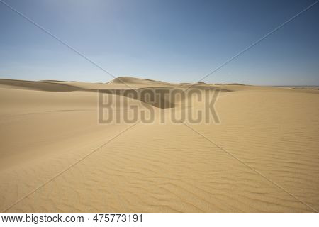 Landscape Scenic View Of Desolate Barren Western Desert In Egypt With Large Sand Dunes Against Blue 