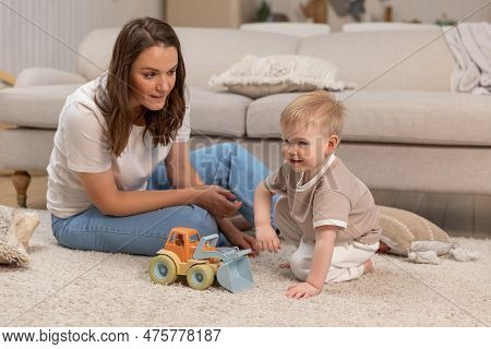 Happy Family At Home. Mother And Baby Boy Playing With Toys At Home Indoors. Little Toddler Child An