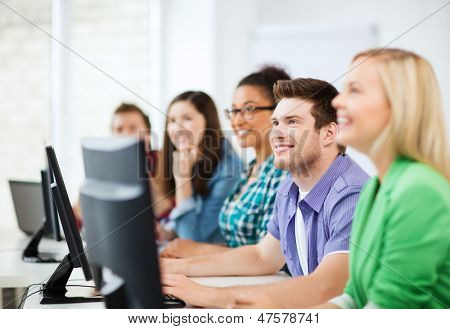 education concept - students with computers studying at school