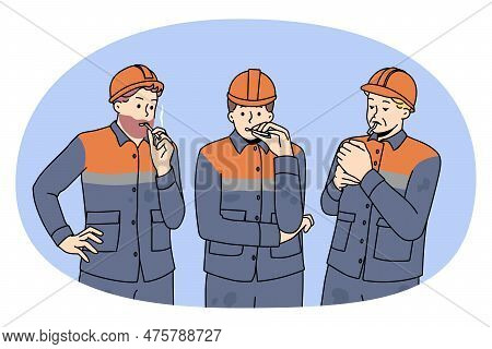 Male Workers In Uniforms Smoking Cigarette Outdoors. Men Builders At Work Have Job Break At Construc