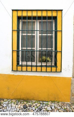 Typical Portuguese Facade With Colorful Window On Cobblestone Street In Evora Town, Portugal