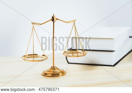 Shiny Golden Balanced Scale And Law Book On Desk In Law School As Concept Justice And Legal Symbol. 