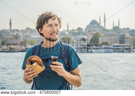 Man In Istanbul Having Breakfast With Simit And A Glass Of Turkish Tea. Glass Of Turkish Tea And Bag