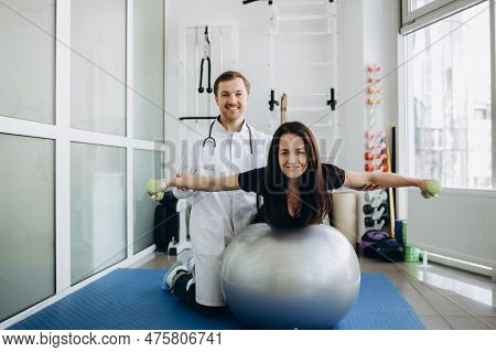 Young Fitness Woman Doing Kinesiotherapy Rehabilitation Exercise With Personal Rehabilitation Specia