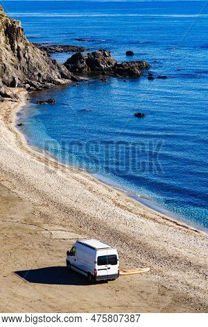 Campervan Rv And Iinflatable Stand Up Board On Beach Sea Shore. Van Life, Holidays In Spain. Recreat