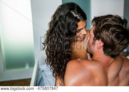 Sensual Young Couple Together In Bed. Happy Couple In Bedroom Enjoying Sensual Foreplay.