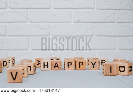 Eco-friendly Cubes. The Word Happy Is Made Up Of Wooden Cubes On A Gray Concrete Background. Front V