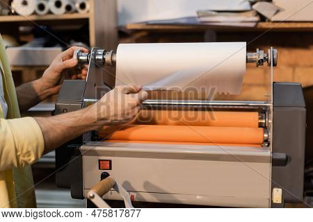 Cropped View Of Worker Pulling Paper While Working With Print Plotter.