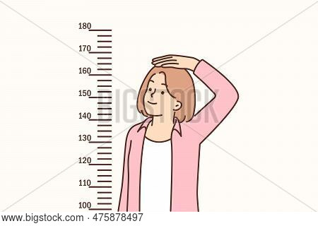 Teenage Girl Measures Height Standing Near Marks On Wall, Wanting To Become Tall And Have Attractive