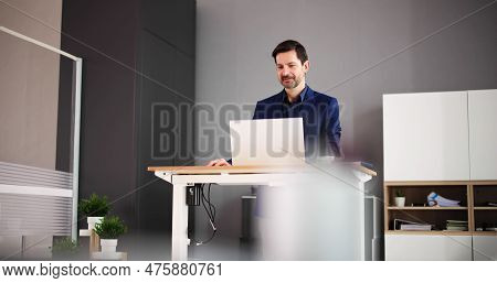 Adjustable Height Desk Stand In Office Using Computer