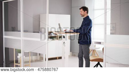 Adjustable Height Desk Stand In Office Using Computer
