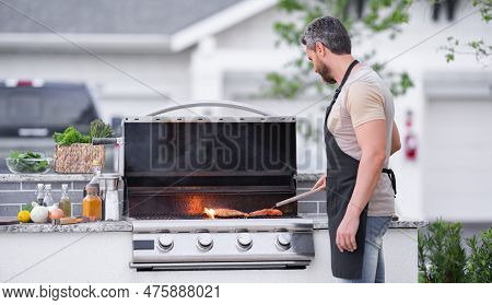 Hispanic Man Cooking On Barbecue In The Backyard. Chef Preparing Barbecue. Barbecue Chef Master. Man