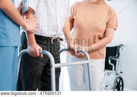 Contented Senior Man Was Helped On Folding Walking By His Wife And Caregiver. Recuperation For Elder
