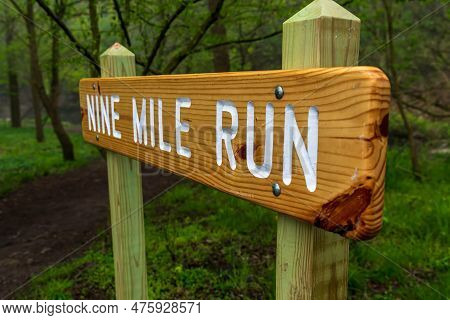 The Nile Mile Run Sign, A Creek In Frick Park In Pittsburgh, Pennsylvania, Usa On A Foggy Spring Mor