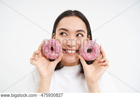 Smiling Korean Woman Eats Pink Glazed Doughnuts, Enjoys Delicious Donnut, Junk Food, Not Care About 