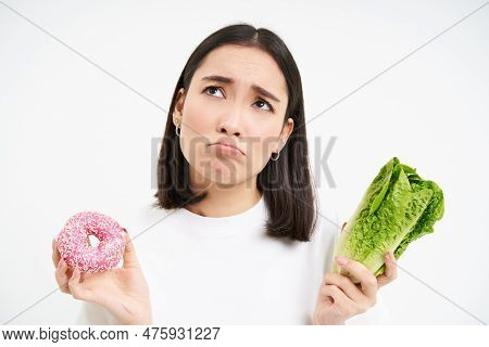 Healthy Clean Detox Eating Concept. Vegetarian, Vegan, Raw Concept. Sad Asian Girl On Diet Holds Dou