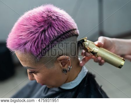 The Hairdresser Shaves The Temple Of A Female Client. Asian Woman With Short Pink Hair In Barbershop
