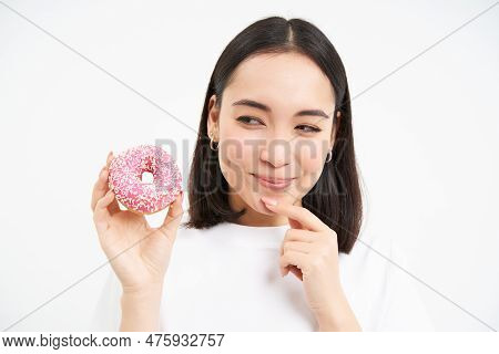 Close Up Of Cute Asian Girl Wants To Bite Tasty Doughnut, Thinking Of Trying Delicious Glazed Donnut