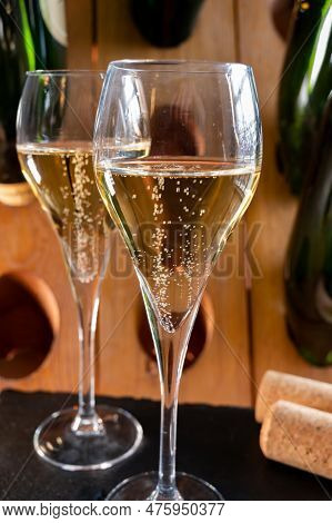 Glasses Of Sparkling White Wine Champagne Or Cava With Bubbles And Classic Wooden Champagne Pupitre