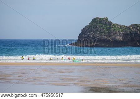 Young Surfers Train On Playa De Palombina Las Camaras In Celorio, Green Coast Of Asturias, North Spa