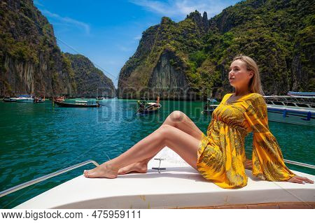 Beautiful Young Blonde Woman In Orange Dress On A Boat Posing During Excursion In Pi Leh Lagon Of Ph