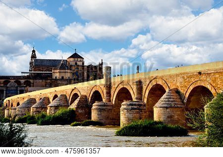 Roman Bridge Over The Guadalquivir River And In The Background The Great Mosque Of Cordoba Or Mosque