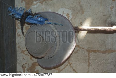 An Old Leather Hat With Feathers Hanging In The Interior Of A Historic Building . A 