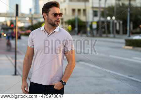 Portrait Of Handsome Male Model Outdoor. Stylish Man Dressed In Polo. Fashion Male Posing On The Str